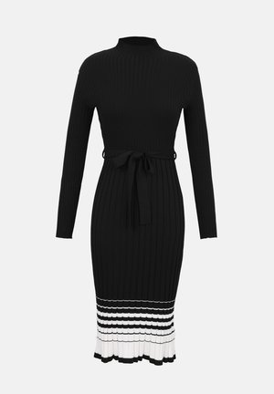 Μαύρο μίντι φόρεμα από πλεκτό ύφασμα με ριγέ υφή, μακριά μανίκια, ψηλό λαιμό, δέσιμο στη μέση και ριγωτή λευκή βολάν στο τελείωμα.