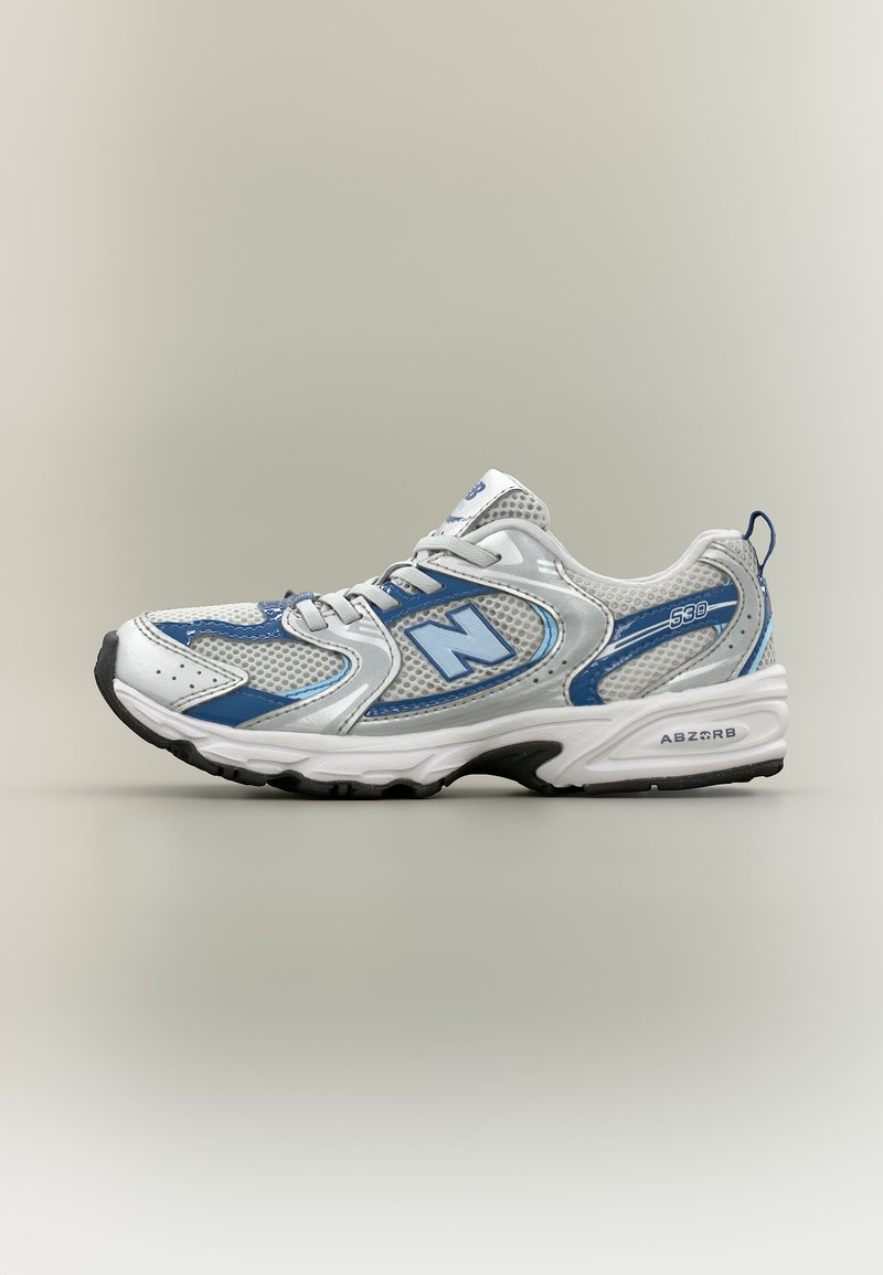 Άσπρο και μπλε αθλητικό παπούτσι New Balance με επάνω μέρος από δίχτυ, κορδόνια, μαλακτικό πέλμα και μαύρη εξωτερική σόλα, εμφανίζεται σε πλάγια όψη σε ουδέτερο φόντο.