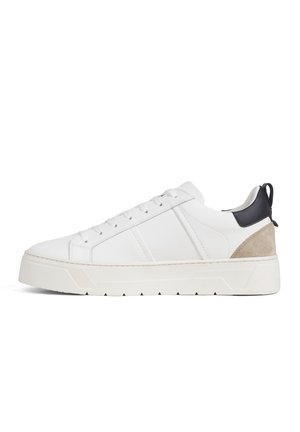 Witte lage sneaker met dikke zool, vetersluiting, zwarte hielriem en beige suède accent aan de achterkant.