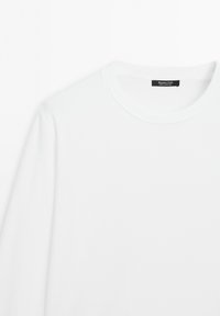 White crewneck long-sleeve shirt with ribbed collar and black label inside neck reading "Massimo Dutti, Made in Portugal."