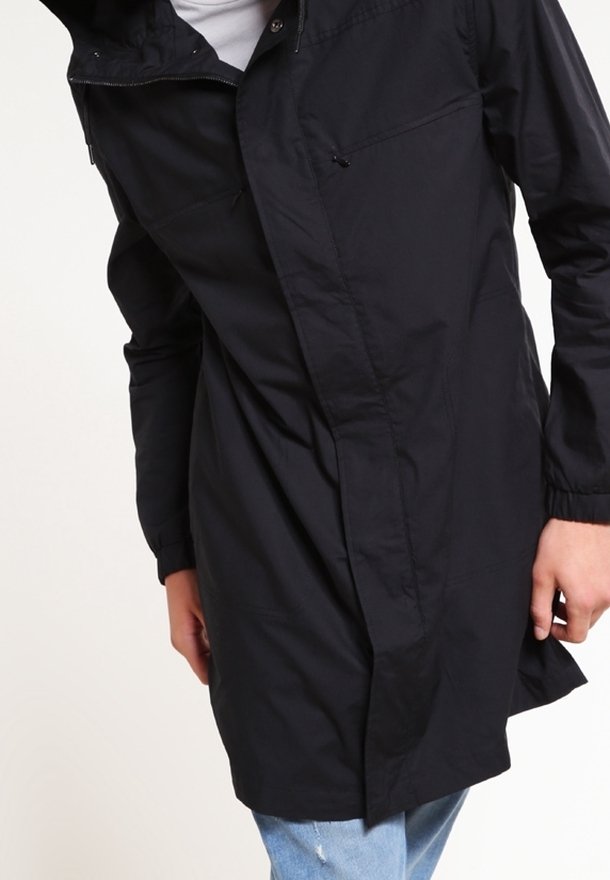 Giacca leggera nera con maniche lunghe e chiusura frontale con zip. Presenta un colletto alto e un design slim e dritto. Ideale per sovrapporre.