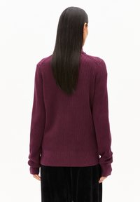 Donkerpaars geribbeld trui met lange mouwen en hoge halslijn, met een aansluitende taille en een gestructureerd breipatroon.