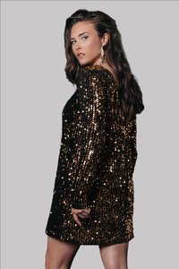 Fekete és arany flitteres ruha hosszú ujjakkal, mély dekoltázzsal és laza fazonnal, csillogó textúrákkal és a comb közepéig érő hosszal.