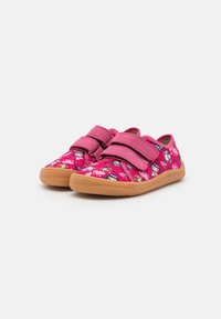 Scarpe in tessuto rosa con un motivo floreale, dotate di due cinturini in Velcro e una suola in gomma marrone chiaro per aderenza e comfort.