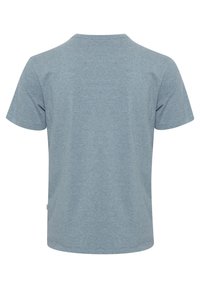 T-shirt s kratkimi rokavi, kroja crew-neck v srednje modri barvi. Narejen iz mehke tkanine z gladko teksturo, z ravnim robom in brez vzorcev.