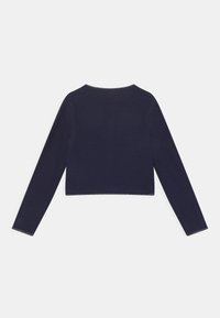 Marinblå kortärmad topp med lång ärm och rund halsringning, tillverkad av textil med struktur, med kontrasterande kant längs kanterna.