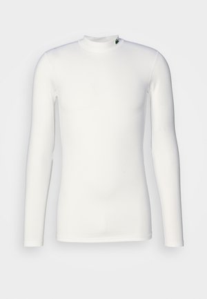 Camisa blanca de manga larga hecha de tejido elástico. Presenta un cuello alto y un pequeño logotipo cerca del escote. Textura suave, diseño ajustado.