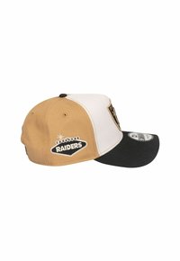 Verstellbare Baseballmütze in tan, weiß und schwarz. Mit einem Raiders-Logo-Patch, gesticktem Text und einem gebogenen Schirm-Design.
