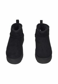 Un paio di stivali neri alla caviglia con suole spesse e rivestimento morbido, vista frontale, isolati su sfondo bianco.