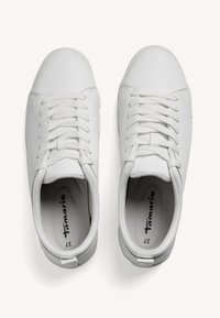 Hvite sneakers med en glatt skinnoverdel, tradisjonell snøring, rund tå, polstret pløse og logo trykt på sålen.