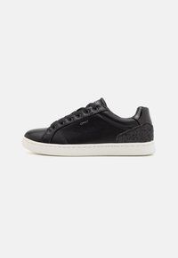 Zapatillas de cuero negro con suela de goma blanca, punta redondeada y acento texturizado negro en el talón. Cuentan con cordones y seis ojales.