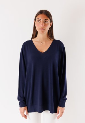 Maglione navy a scollo a V con maniche lunghe, polsini a coste e vestibilità comoda. Realizzato in materiale morbido, presenta una texture liscia e un design minimal.
