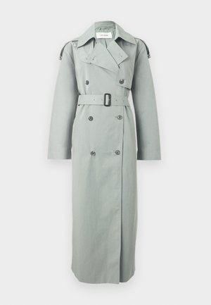 Trench coat lung, dublu cu nasturi, gri deschis, cu revere late, cataramă neagră, detalii cu nasturi și epoleți pe mâneci.