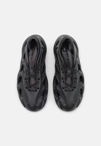 Svarta sportskor med en texturerad ovandel, snörning, framträdande utskärningsdesign och en vadderad ankeldel för stöd.