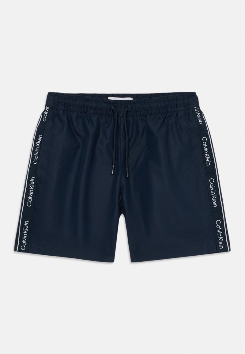Shorts de bain navy avec une taille élastique, fermeture à cordon de serrage et bandes latérales arborant le logo "Calvin Klein" en blanc. Tissu lisse.