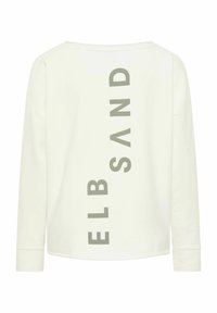 Chemise à manches longues crème avec un col rond et un texte vertical gris indiquant "ELB SAND" au dos. Tissu en coton doux, coupe décontractée.