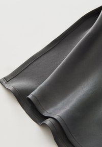 Grauer Satin-Stoff mit glatter Textur, der einen leicht gebogenen Rand und eine saubere Naht entlang des Saums aufweist. Weicher Fall sichtbar.