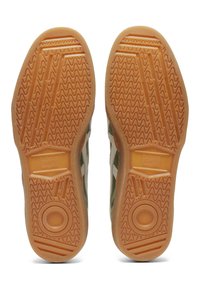 Zelené a béžové nízké tenisky s texturovanými gumovými podrážkami. Výrazný vlnitý vzor a kruhové akcenty na podrážce.