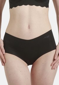 Schwarze hochgeschnittene Unterwäsche aus glattem Stoff, mit nahtlosem Design und einem kleinen Logo-Element am Bund.