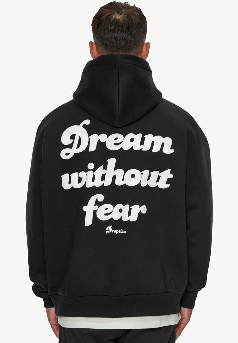 Hoodie noir avec un grand design en texte blanc au dos indiquant "Rêve sans peur" et le logo "Dropsize", comprenant une capuche avec cordon.