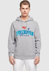 Gray hoodie with a front pocket. Features a red Superman logo and blue text reading "SUPERMAN LOOK UP IN THE SKY." Made of cotton blend.