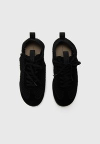 Scarpe nere con tomaia in rete e dettagli in suede, dotate di lacci e linguette, che evidenziano un design elegante e a profilo basso.