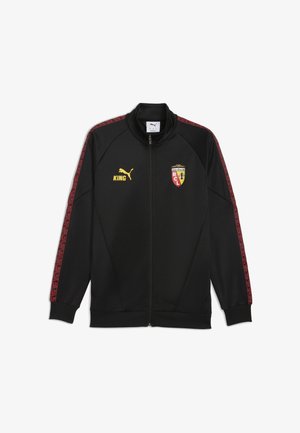Sort atletisk jakke med høj krave, lynlås foran, røde mønstrede sidepaneler, gult "KING" logo og klubemblem på brystet. Blødt materiale.