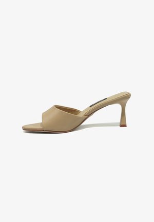 Beige Mule mit offenem Zehenbereich, niedrigem, geschwungenem Stöckelabsatz und glattem Lederobermaterial auf weißem Hintergrund.