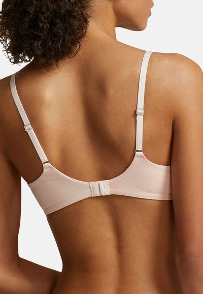 Ljust rosa tyg-bh med justerbara band, krok-och-ögon stängning och slät textur. Enkelt design utan ytterligare mönster eller försköningar.