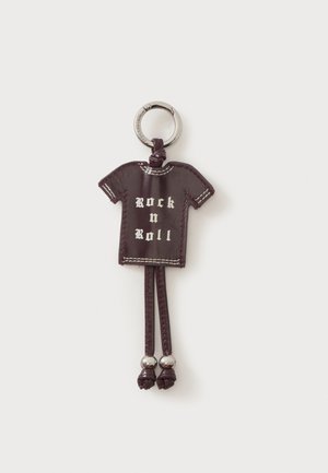 Porte-clés en cuir foncé en forme de t-shirt avec le texte "Rock n Roll" et deux pompons en cuir terminés par des perles métalliques.