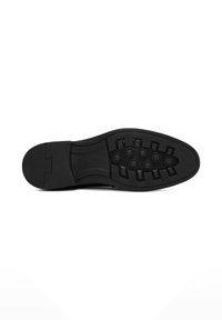 Zwarte schoenzool met getextureerd rubber voor grip, voorzien van cirkelvormige indeukingen en flexibele groeven, gladde rand en plat ontwerp.