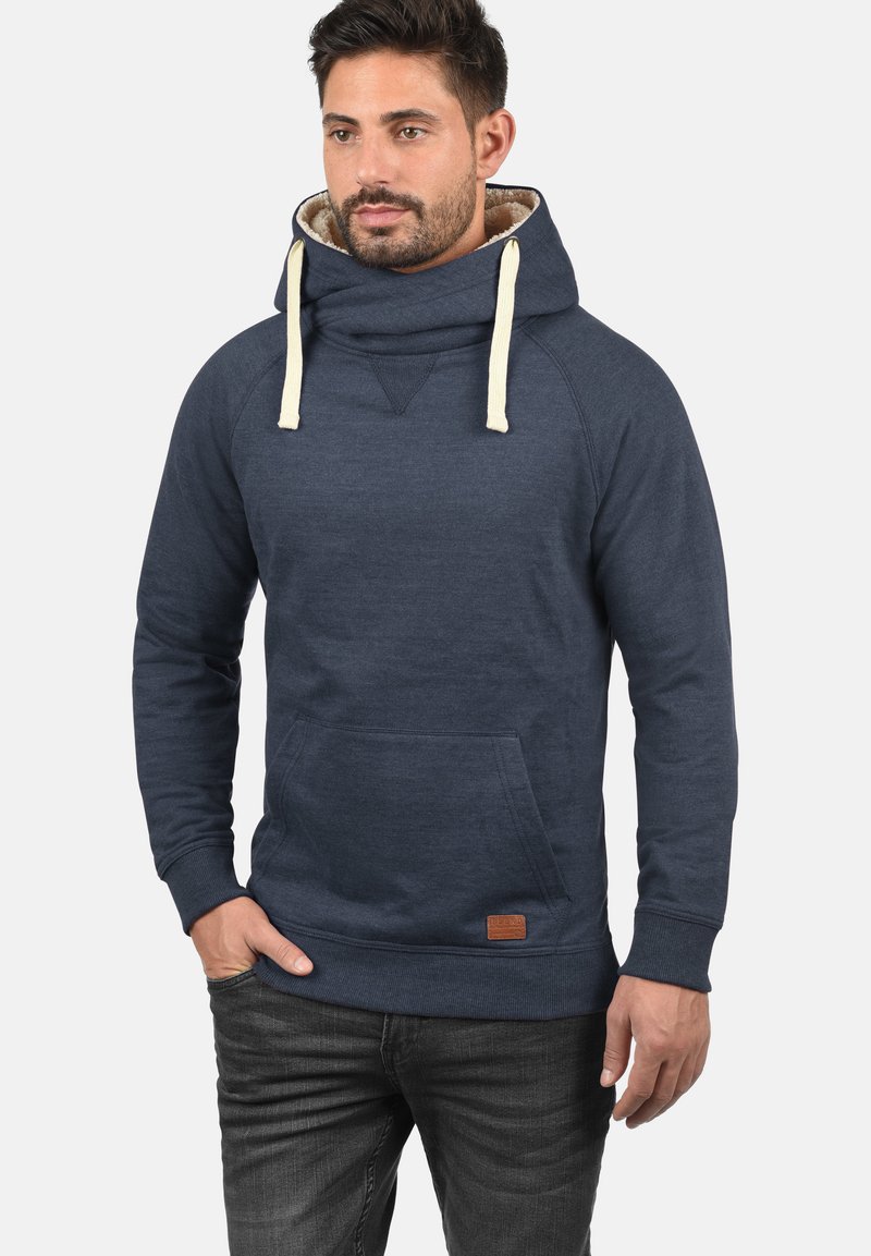 Felpa blu navy con collo alto a funnel, lacci beige, tasca a marsupio, polsini a coste e una patch in pelle sul lato inferiore.