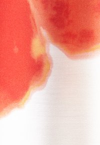 Tissu rouge, orange et blanc avec une texture lisse et fluide et un motif en dégradé mélangeant les couleurs.
