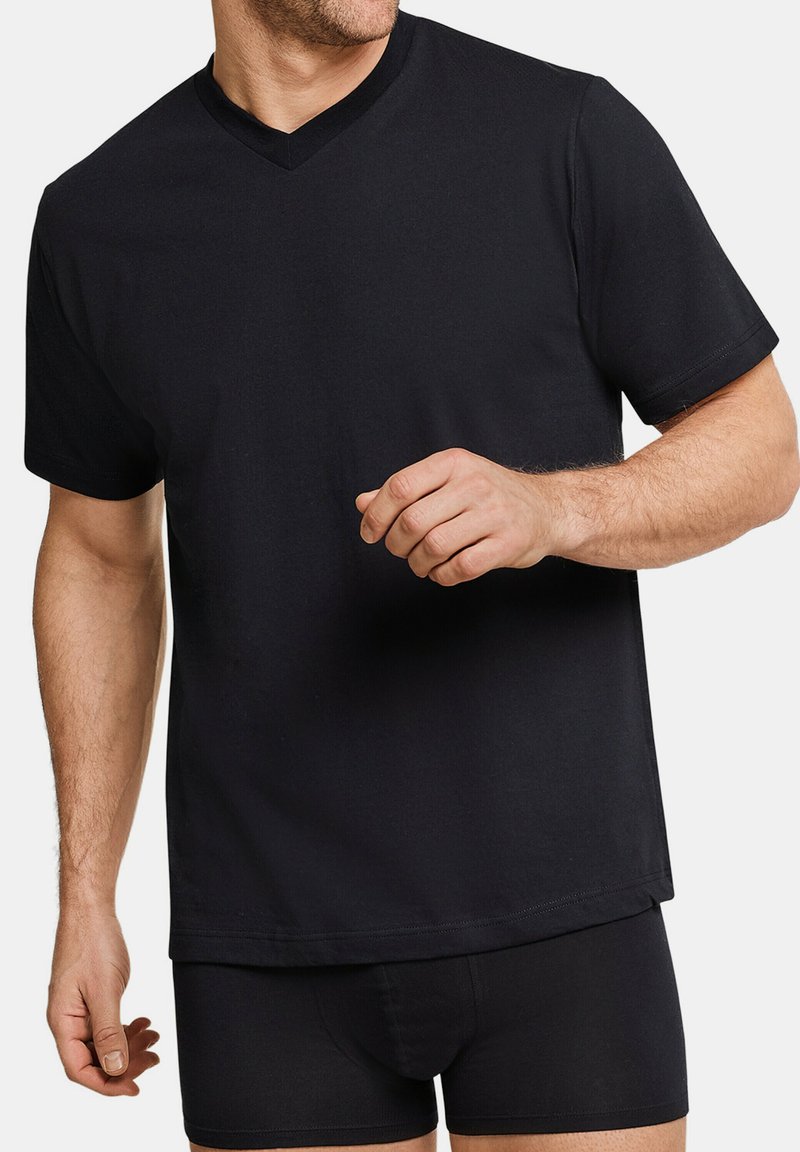 T-shirt nera a scollo a V in cotone, con maniche corte e vestibilità rilassata, abbinata a boxer neri. Texture liscia, senza fantasie.