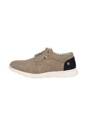 Zapato casual beige con cordones, suela blanca, forro interior a rayas y parche negro en el talón con un pequeño logo metálico redondo.