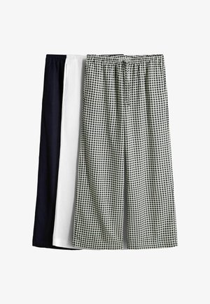 Drei Paare Loungehosen mit elastischem Bund und Kordelzug, in Schwarz, Weiß und schwarz-weiß kariert, nebeneinander dargestellt.