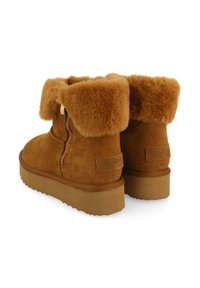 Botas de tobillo de ante marrón con puño de piel sintética y cremallera lateral. Con suela de goma gruesa y texturizada para mayor tracción. Sin marcas de marca visibles.