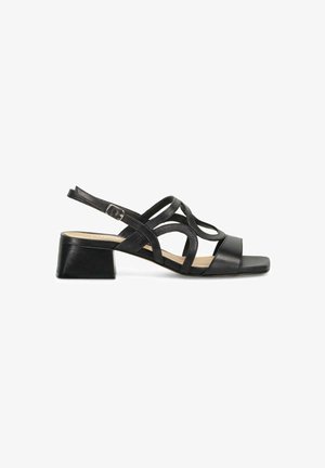 Sandale en cuir noir avec un bout carré, des lanières croisées fines et un petit talon carré. Comprend une boucle pour l'ajustement.
