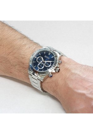 Silver stainless steel watch with a dark blue dial, three sub-dials, and silver markings. The band features a polished link design.