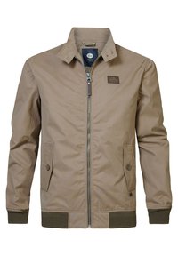 Béžová bomber bunda se zipem vpředu, klopovými límci, dvěma postranními kapsami, žebrovanými manžetami a lemem. Na hrudi je umístěna nenápadná značka.