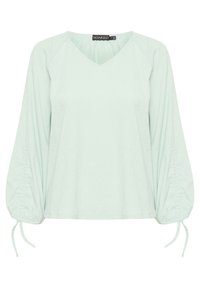 Blusa verde menta con scollo a V, maniche lunghe a sbuffo con dettagli arricciati e lacci regolabili ai polsini. Tessuto morbido e strutturato.