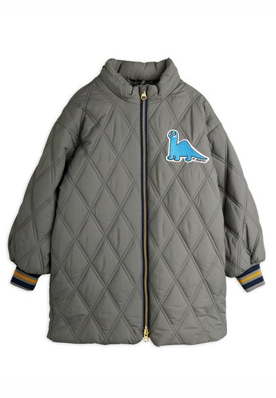 Pelēks quilted bērnu mētelis ar priekšējo rāvējslēdzēju, ribotām piedurknēm ar dzeltenām un tumši zilām svītrām, un zilu dinozaura uzplecu uz krūtīm.