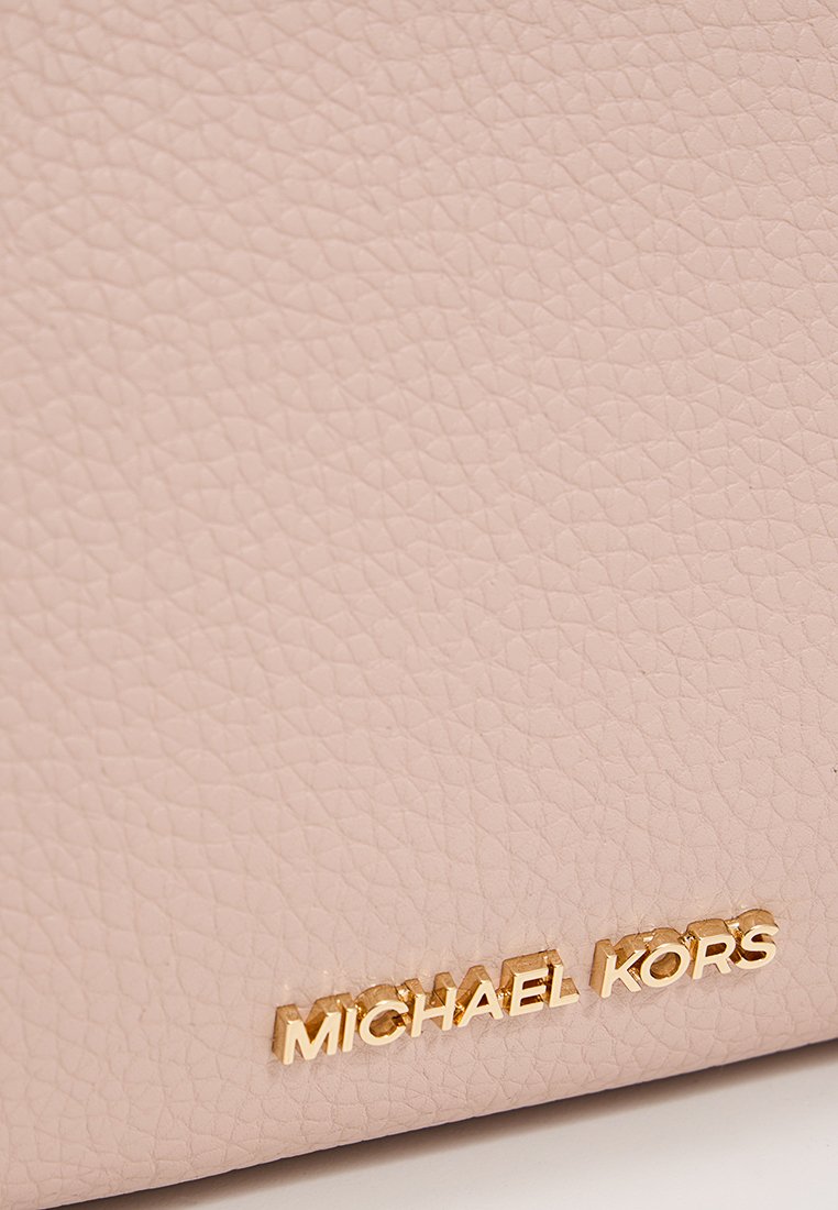 Lichtroze leren tas met een gestructureerd oppervlak en een gouden "MICHAEL KORS" logo-accent aan de voorkant.