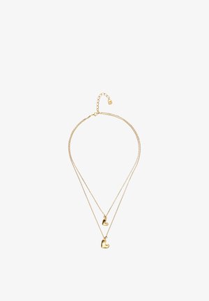 Collar de oro de doble capa con dos colgantes en forma de corazón, uno más pequeño encima del más grande, en cadenas finas con cierre ajustable.
