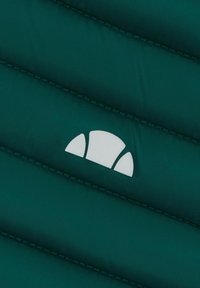 Zielona pikowana tkanina z poziomym przeszyciem i widocznym białym logo. Tekstura jest gładka i lekko błyszcząca.