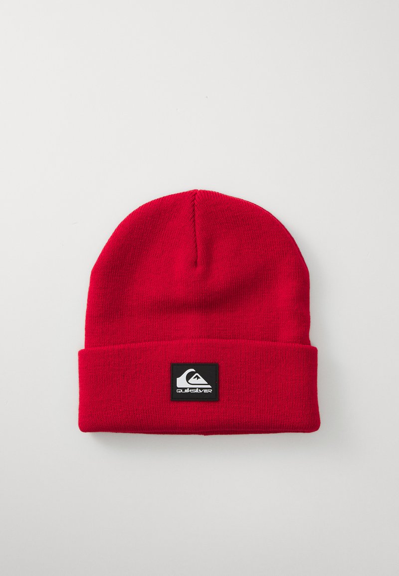 Rode gebreide beanie met een omgeslagen rand en een vierkant zwart label met een wit berglogo. Soepel textuur en een snug fit.