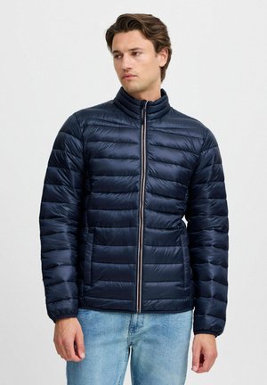 Marineblauer Pufferjacke mit horizontalen Nähten, hohem Kragen, Frontreißverschluss und zwei Seitentaschen. Leicht, glatte Textur.