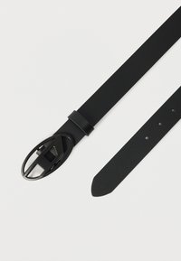 Μαύρη ζώνη από υλικό με υφή που διαθέτει αγκράφα οβάλ σχήματος με σχέδιο κοπής και πολλαπλές οπές ρύθμισης.