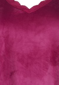Top in velluto di un profondo magenta con scollatura in pizzo ondulato. Texture liscia, design a V e colore unito senza motivi o decorazioni.