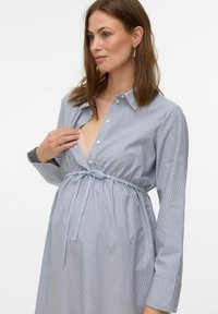 Abito premaman a righe in cotone azzurro chiaro. Caratterizzato da una vita con lacci, chiusura a bottoni e maniche lunghe. Tessuto morbido e vestibilità comoda.